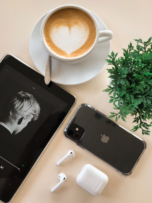 Mit AirPods auf dem Handy zum Nachmittagskaffee Musik hören.